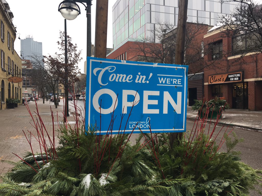 A downtown London sign alerts residents that businesses remain open despite road construction. 