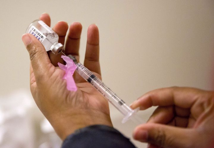 A nurse prepares a flu shot at the Salvation Army in Atlanta. According to the CDC, flu costs the nation about $7 billion a year in sick days and lost productivity among working-age adults. ThatÄôs not to mention the heavy toll of hospitalizations and deaths that occur mainly among people 65 and older. 