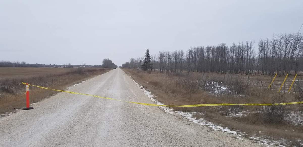 Police tape blocks off a rural road in the RM of Gimli Sunday.