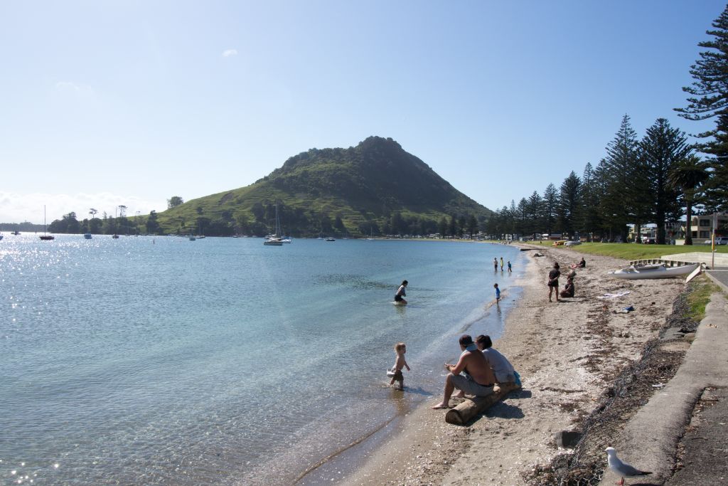 People enjoying on a beach under the Mount Maunganui in Tauranga, North Island, New Zealand, October 30, 2017.  