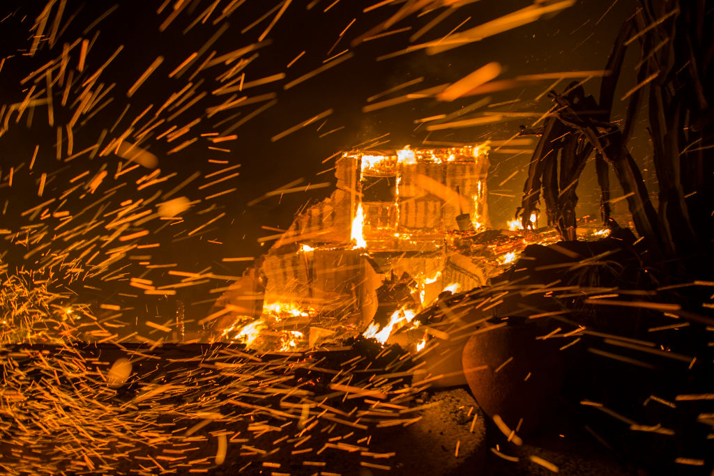 Strong winds blow embers from burning houses during the Woolsey Fire on November 9, 2018 in Malibu, California.