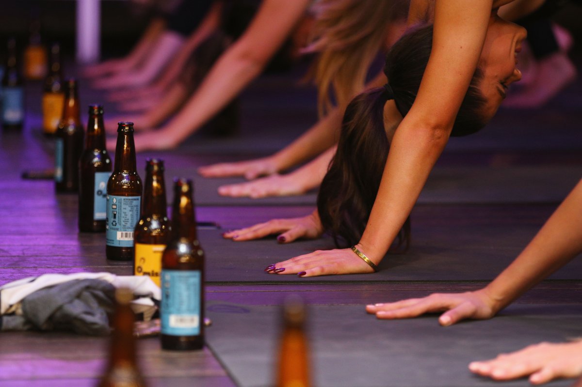 Participants perform stretches at a Beer Yoga class .