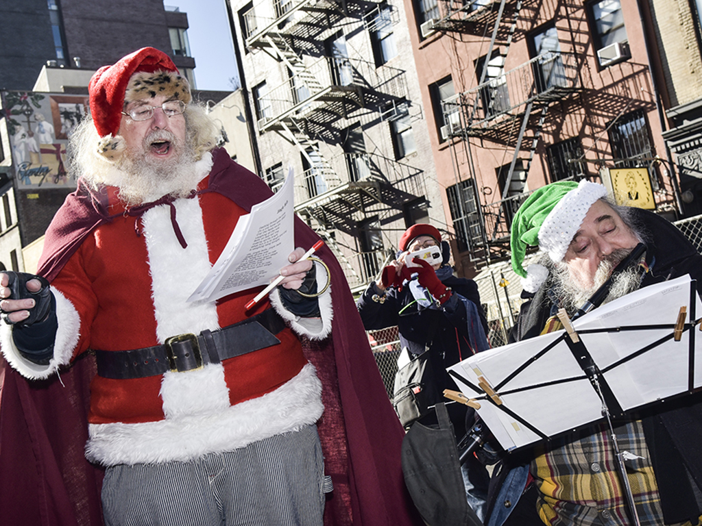 Andrew Bolotowsky  with Santa Claus and members of Earth is Our Mother sing Christmas carols at Petronsino Square on Dec. 21, 2017 in New York City. 