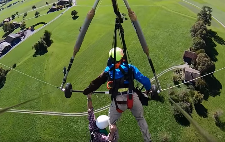 First-time hang glider hangs on for dear life after pilot forgets to attach him - image