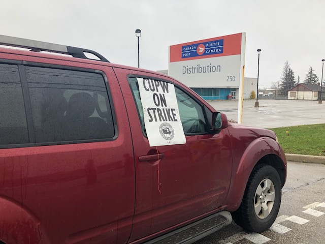 Picketers blocked off the entrance to Canada Post's distribution centre in Guelph on Monday as part of rotating strikes across the country. 