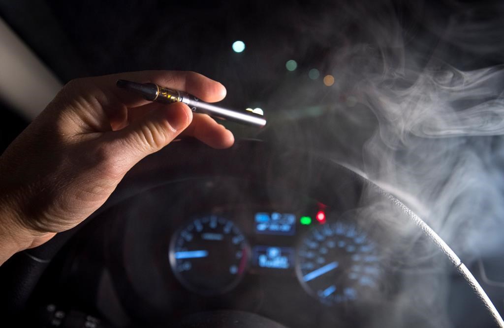 In this photo illustration, smoke from a cannabis oil vaporizer is seen as the driver is behind the wheel of a car in North Vancouver, B.C. Wednesday, Nov. 14, 2018.