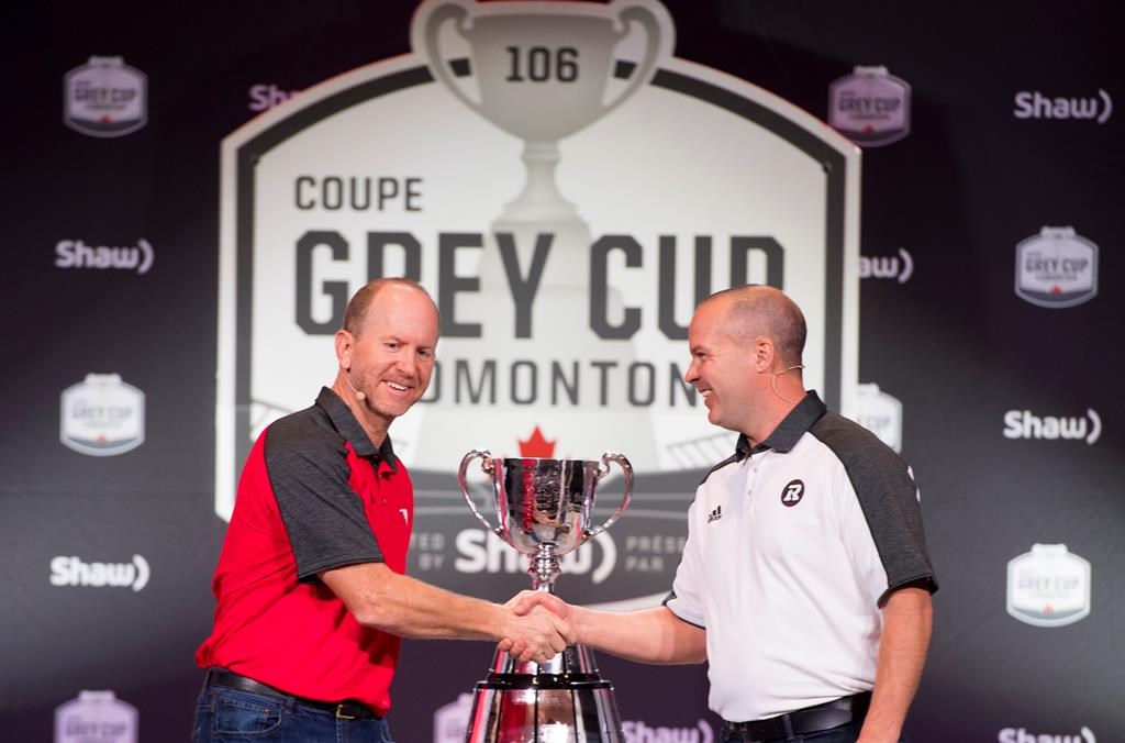 Calgary Stampeders head coach Dave Dickenson, left, and Ottawa Redblacks head coach Rick Campbell, right, arrive for the head coaches news conference in Edmonton, Alta. Wednesday, Nov. 21, 2018. The 106th Grey Cup will be played Sunday between the Ottawa Redblacks and the Calgary Stampeders.