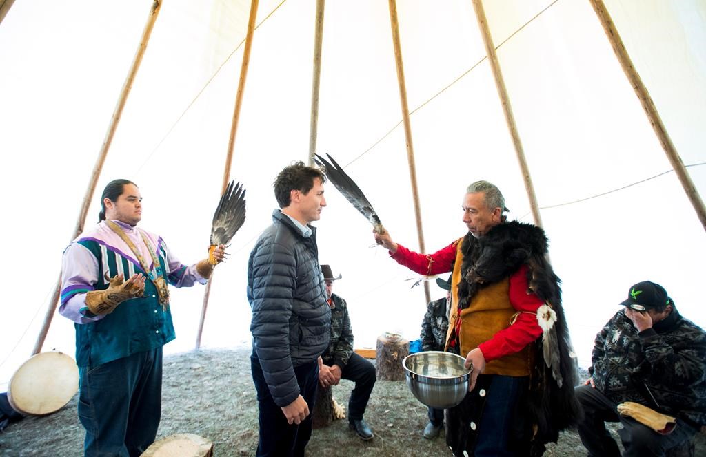 Prime Minister Justin Trudeau receives a water cleansing by spiritual leader Cecil Grinder along with Chiefs of the Tsilhqot'in National Government near Chilko Lake, B.C., Friday, Nov. 2, 2018.