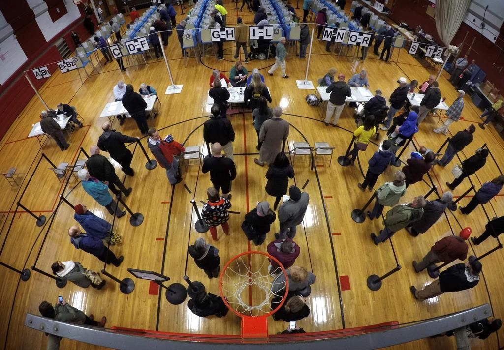 Voters wait in line in the gymnasium at Brunswick Junior High School to receive their ballots for the mid-term election, Tuesday, Nov. 6, 2018, in Brunswick, Maine. (AP Photo/Robert F. Bukaty)
