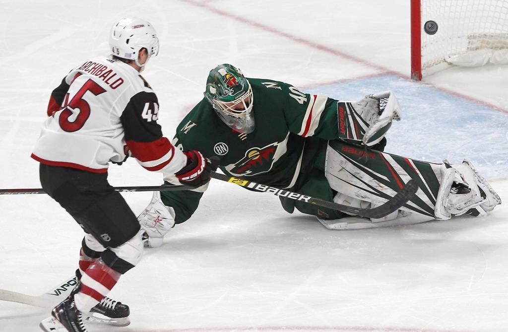 Arizona Coyotes' Josh Archibald, left, scores his second of two third-period goals off Minnesota Wild goalie Devan Dubnyk, right, during an NHL hockey game Tuesday, Nov. 27, 2018, in St. Paul, Minn.