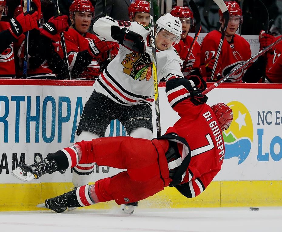 The Carolina Hurricanes’ Phillip Di Giuseppe (7) collides with the Chicago Blackhawks’ Luke Johnson (62) during the second period of an NHL hockey game, Monday, Nov. 12, 2018, in Raleigh, N.C. (AP Photo/Karl B DeBlaker)