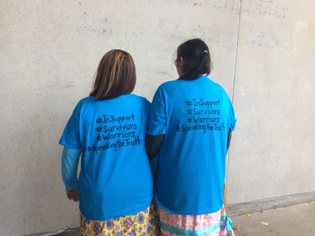 Two supporters of the victims who accused David Norton of sexual abuse show off their T-shirts outside the London courthouse on Tuesday, Nov. 6, 2018. 