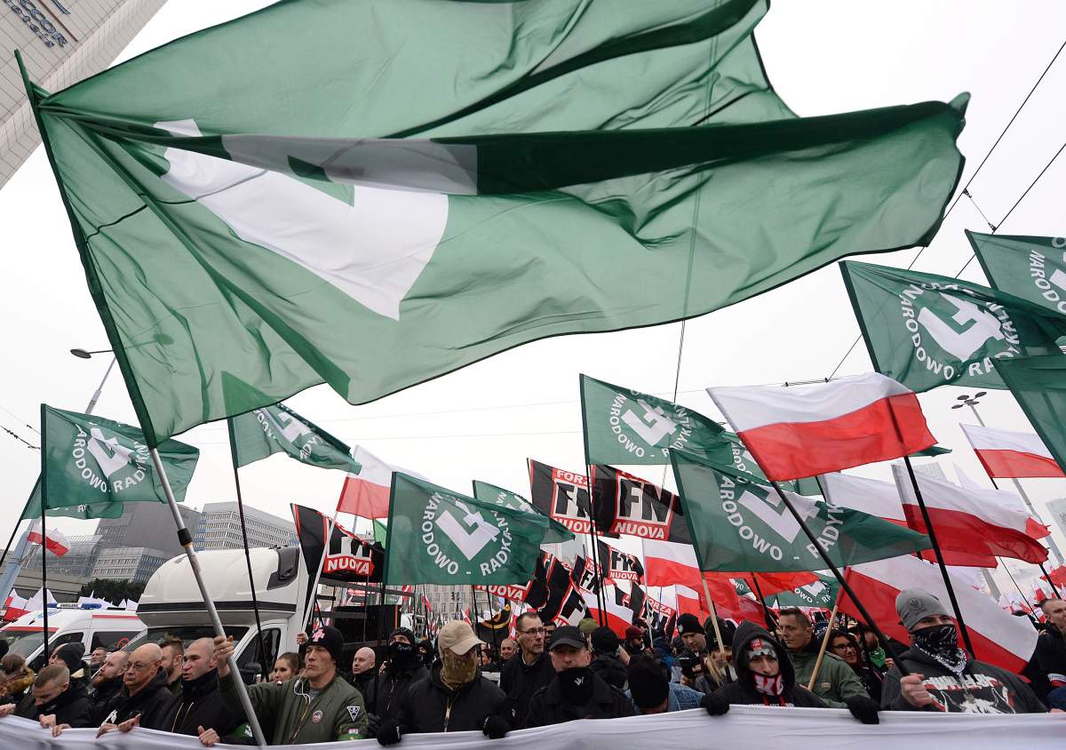 Members of radical right-wing groups wave flags during a march by tens of thousands of people and hosted by President Andrzej Duda that marked 100 years since Poland regained independence in Warsaw, Poland, Sunday, Nov. 11, 2018.