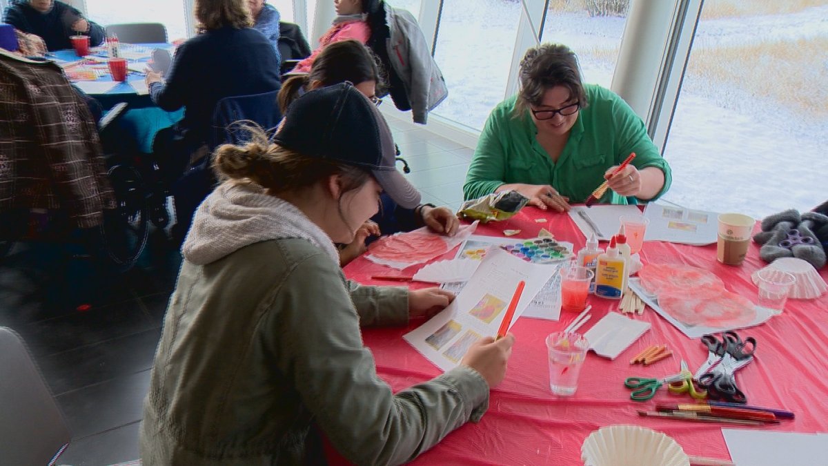 Participants at a poppy art workshop make their own poppies at the Galt Museum.