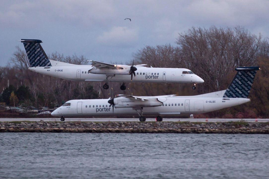 A Porter Airlines plane lands next to a taxiing plane at Toronto's Island Airport on November 13, 2015. 