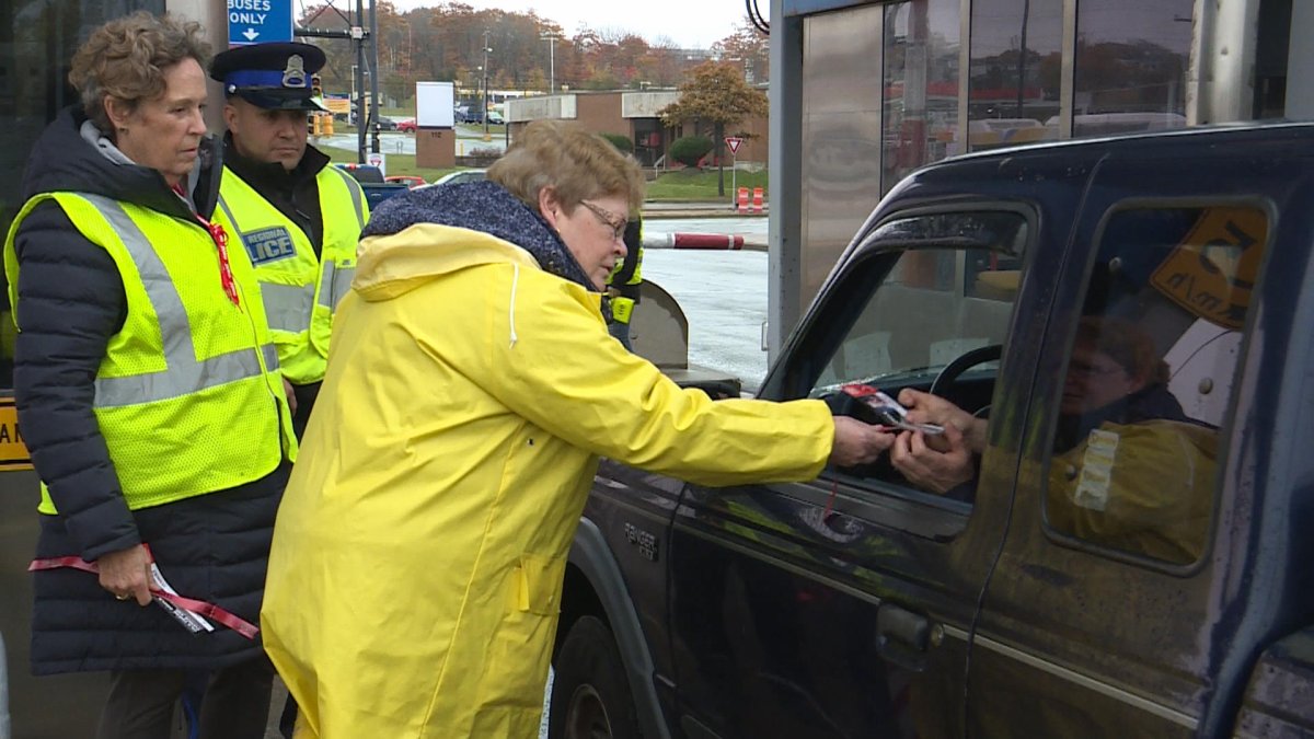 Volunteers hand out red ribbons as part of the annual MADD Canada campaign at the Angus L. Macdonald bridge Thursday Nov. 1. 