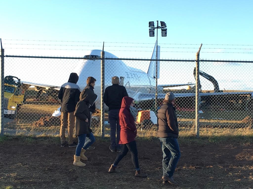 A Boeing 747 cargo jet sits off the runway near the perimeter of Halifax Stanfield International Airport in Halifax, Sunday, Nov.11, 2018. Crews have begun tearing into the mangled Boeing 747 cargo jet that overshot a Halifax runway last week, as gawkers marvelled at the huge wreck -- and how close it came to breaching the airport's fence and overrunning a public road.