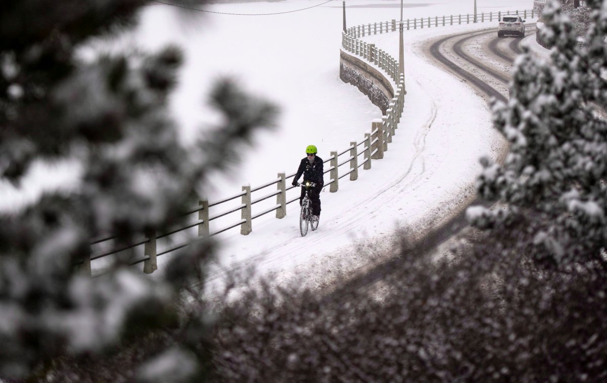 A cyclist makes their way along the Rideau Canal Eastern Pathwa after the first major snowfall of the season in Ottawa on Friday, Nov. 16, 2018.