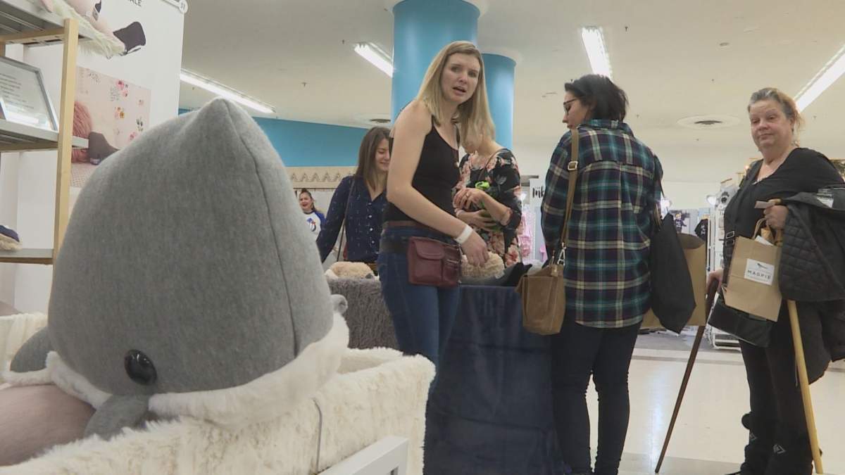Wendi Kuarsingh, right, shows off her whale pillows to customers.