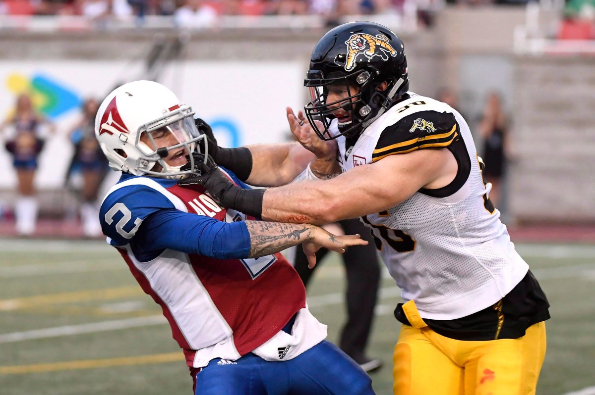 Montreal Alouettes quarterback Johnny Manziel (2) is hit by Hamilton Tiger-Cats defensive end Jason Neill (96) during first quarter CFL football action in Montreal on Friday, Aug. 3, 2018.