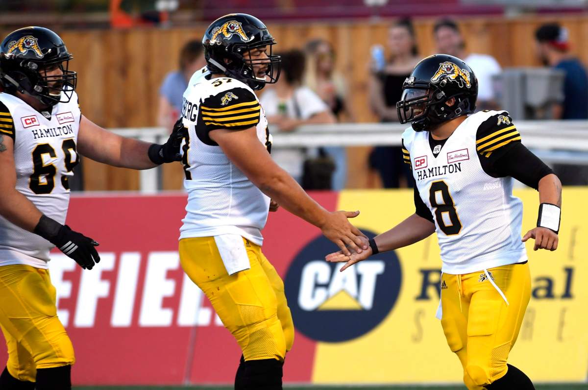 Hamilton Tiger-Cats quarterback Jeremiah Masoli (8) celebrates a conversion against the Ottawa Redblacks with Brandon Revenberg (57) and Landon Rice (60) during the first half of a pre-season CFL football game in Ottawa on Thursday, June 8, 2017. 