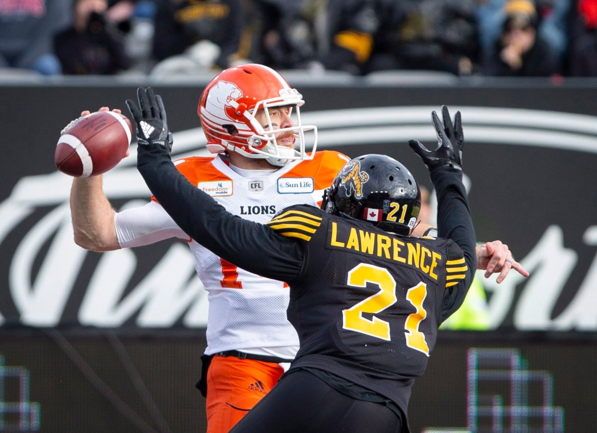 B.C. Lions quarterback Travis Lulay (14) is pressured by Hamilton Tiger-Cats linebacker Simoni Lawrence (21) during first half CFL Football division semifinal game action in Hamilton, Ont. on Sunday, November 11, 2018.