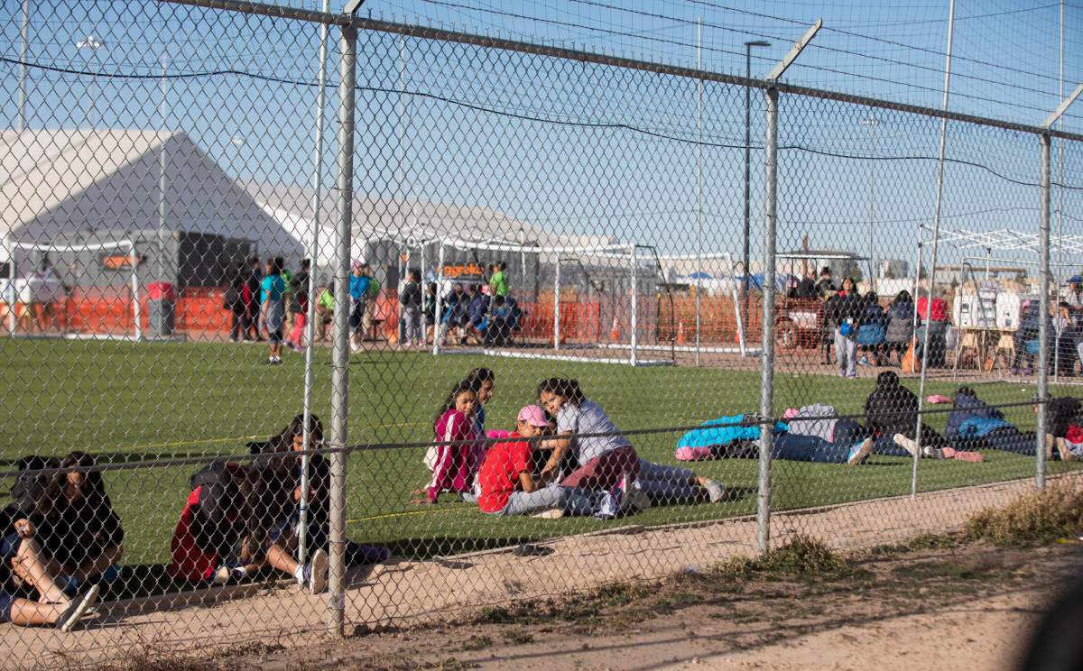 In this Nov. 25, 2018 photo provided by Ivan Pierre Aguirre, migrant teens held inside the Tornillo detention camp sit inside the facility in Tornillo, Texas.