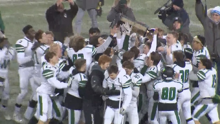 The Vincent Massey Trojans celebrate their ANAVETS Bowl victory over the St. Paul's Crusaders at Investors Group Field.