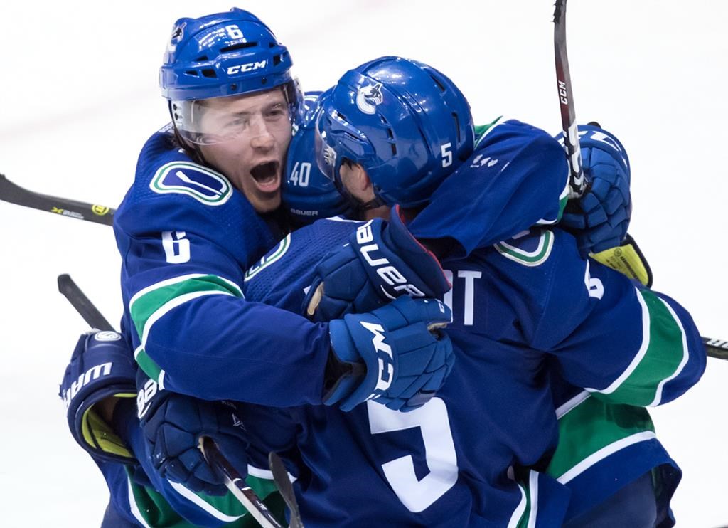 Vancouver Canucks' Brock Boeser, from left, Elias Pettersson, of Sweden, and Derrick Pouliot celebrate Pouliot's winning goal against the Colorado Avalanche during overtime NHL hockey action in Vancouver, on Friday November 2, 2018.