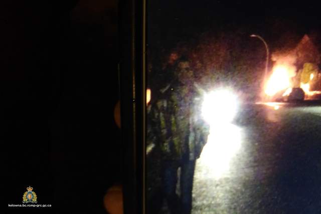 Photograph taken of the unknown man, police are considering a person of interest in a vehicle fire on Saturday night. The male is described as approximately six feet tall with brown hair, and wearing a yellow plaid jacket and dark coloured pants.