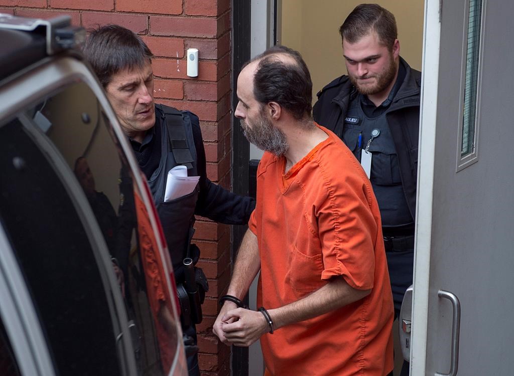 Matthew Vincent Raymond, charged with four counts of first degree murder, heads from provincial court in Fredericton on Monday, Nov. 5, 2018.