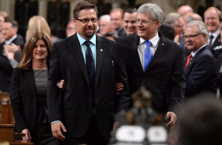 Former prime minister Stephen Harper and former health minister Rona Ambrose escort Conservative MP David Yurdiga in the House of Commons in Ottawa on September 15, 2014. 