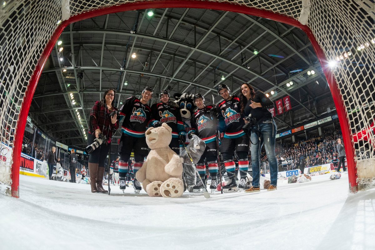 Kelowna Rockets' team photographers Cindy Rogers and Marissa Baecker, pose with mascot Rocky Raccoon and Conner Bruggen-Cate #20, Mark Liwiski #9, Michael Farren #16 and Erik Gardiner #11 of the Kelowna Rockets for a net cam selfie during the annual Teddy Bear Toss against the Saskatoon Blades  on December 1, 2018 at Prospera Place in Kelowna.