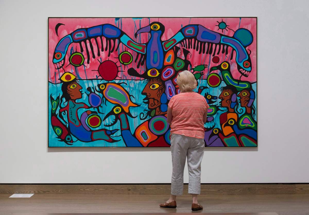 A woman surveys the painting "Copper Thunderbird" by Norval Morrisseau on display during a media tour of the National Gallery of Canada's Canadian and Indigenous Galleries featuring Canadian and Indigenous Art: From Time Immemorial to 1967 in Ottawa, Wednesday, June 7, 2017. 
