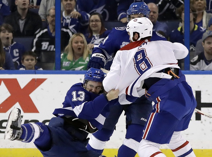In this March 2018 file photo, Tampa Bay Lightning center Cedric Paquette (13) goes down as he fights Montreal Canadiens defenseman Jordie Benn (8) during the third period of an NHL hockey game in Tampa, Fla.