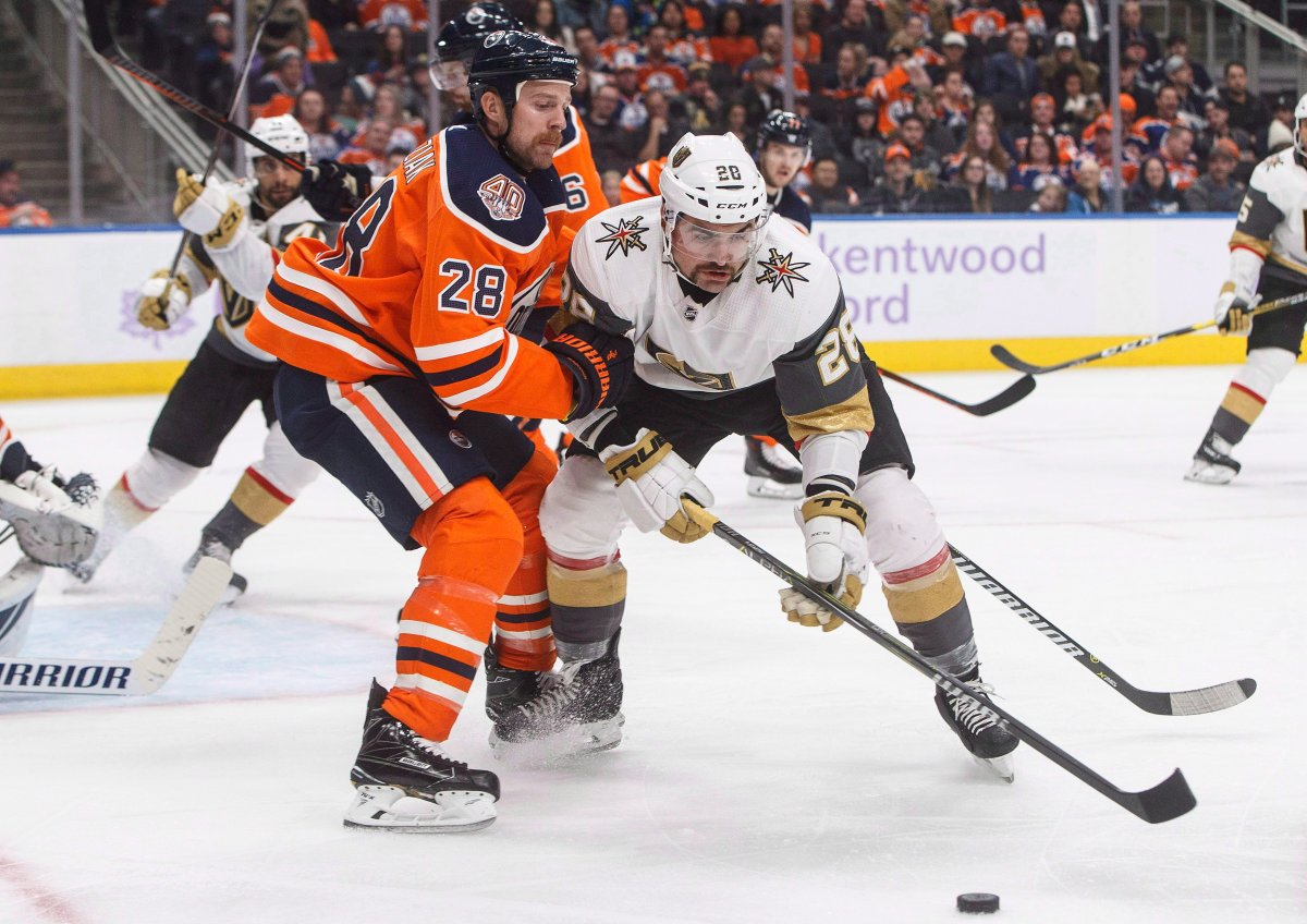 Vegas Golden Knights' William Carrier (28) and Edmonton Oilers' Kyle Brodziak (28) battle for the puck during third period NHL action in Edmonton, Alta., on Sunday November 18, 2018. THE CANADIAN PRESS/Jason Franson.