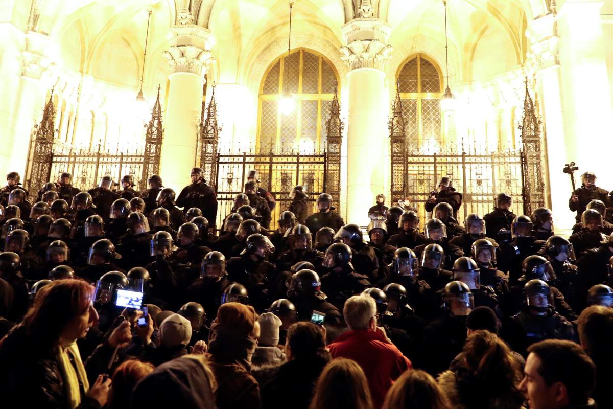 Police stand guard as people attend a protest against the new labour law in front of the Parliament building in Budapest, Hungary, December 12, 2018.