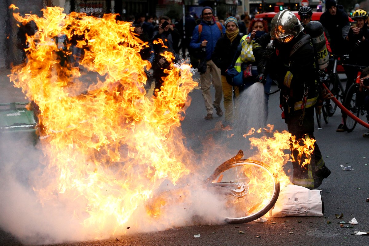 FILE PHOTO: A firefighter extinguishes a burning bicycle during clashes with yellow vests protesters as part of a national day of protest by the "yellow vests" movement in Paris, France, December 8, 2018. 
