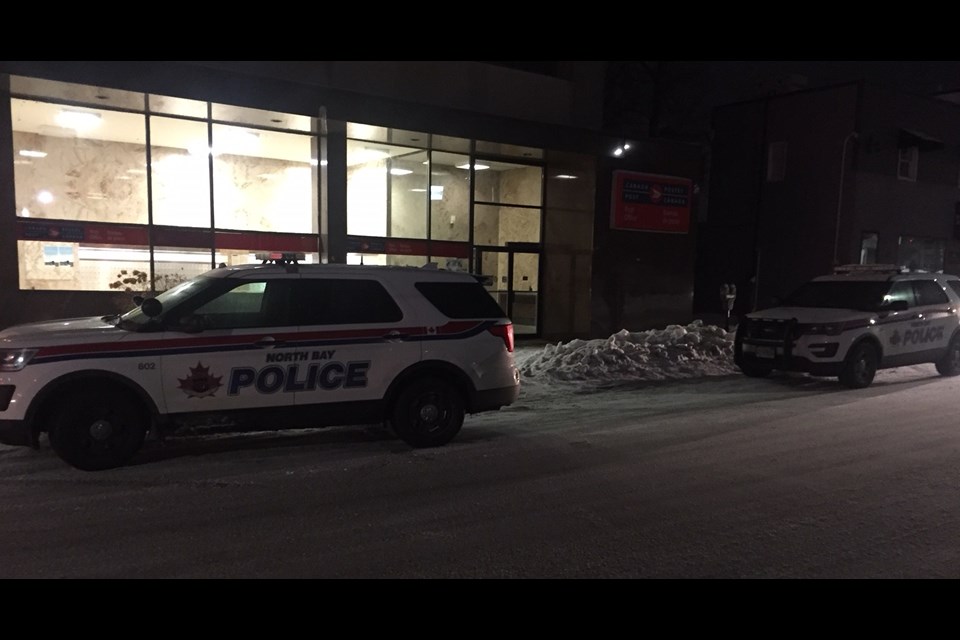 A pair of police cruisers sit outside after a bomb threat was called in to the Canada Post building.