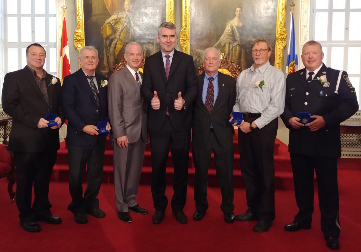 Kevin Tough, James Dufour, Justice Minister Mark Furey, Premier Stephen McNeil, chair of the Medal of Bravery advisory committee Hugh Laurence, Paul Rowe and 
Bruce Knocton pose for a photo on Dec. 4, 2018. 