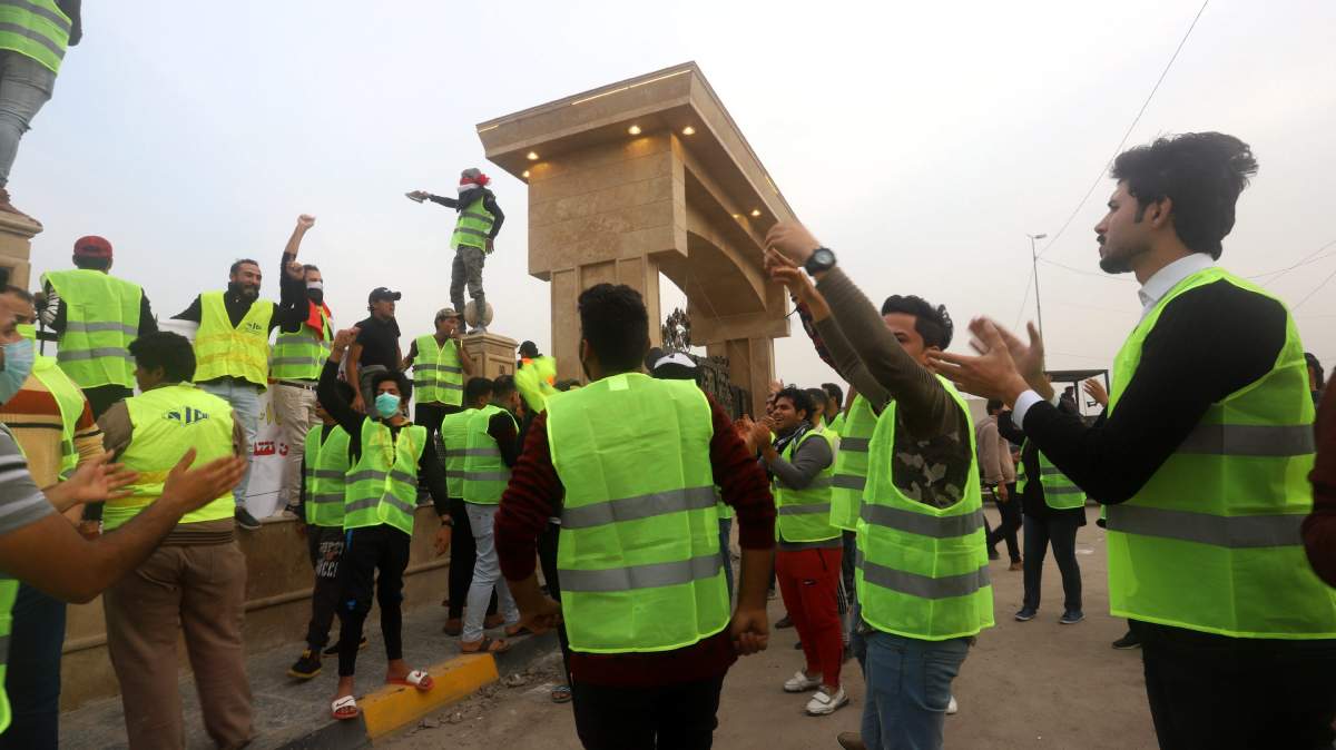 Iraqi protesters wearing yellow vests take part in a demonstration in front of the local government building in Basra city, southern Iraq.