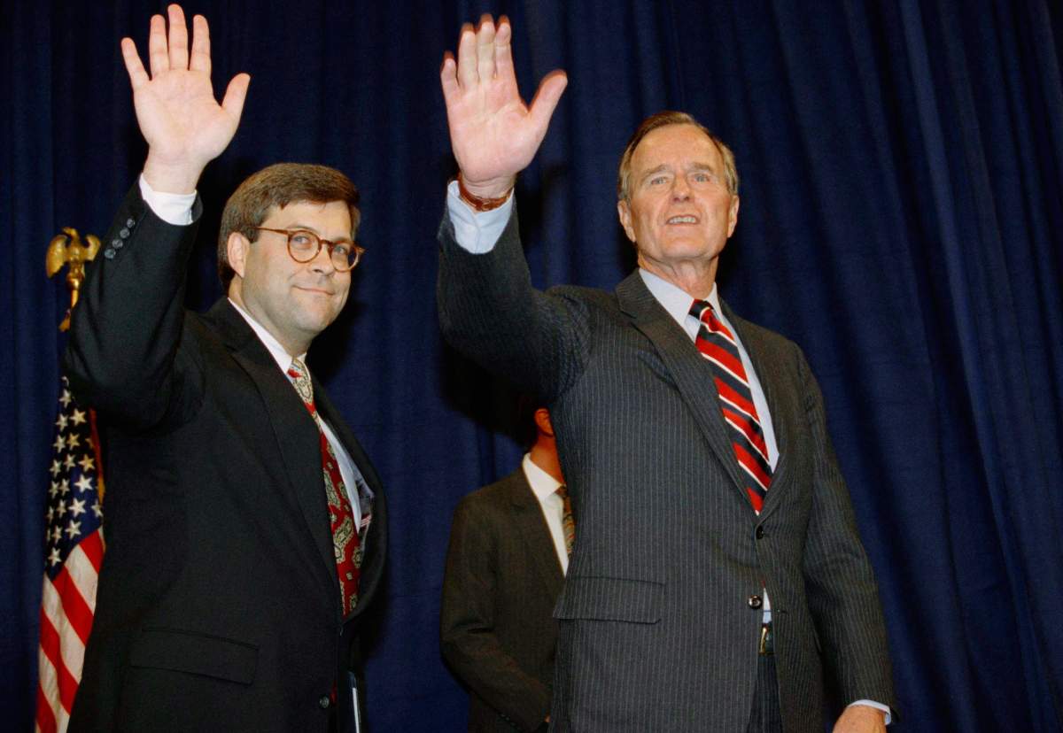 In this Nov. 26, 1991, file photo, President George H.W. Bush, right, and William Barr wave after Barr was sworn in as the new Attorney General of the United States at a Justice Department ceremony in Washington.