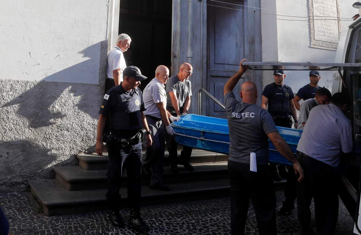 Police remove the body of a shooting victim from the Metropolitan Cathedral in Campinas, Brazil, on Tuesday, Dec. 11, 2018. A man opened fire in the cathedral after mass on Tuesday, killing four and leaving four others injured before taking a bullet in the ribs in a firefight with police and then shooting himself in the head, according to authorities.