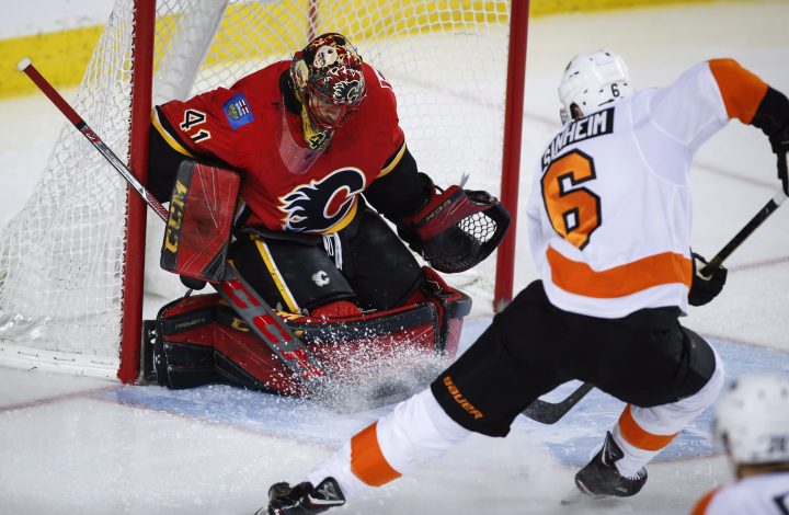 Philadelphia Flyers' Travis Sanheim, right, scores on Calgary Flames goalie Mike Smith during second period NHL hockey action in Calgary, Wednesday, Dec. 12, 2018.