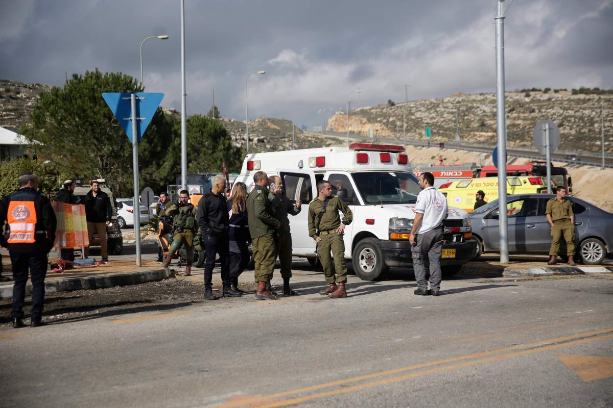 Israeli soldiers stand at the scene of an attack near the settlement of Givat Assaf in the West Bank, Thursday, Dec. 13, 2018.