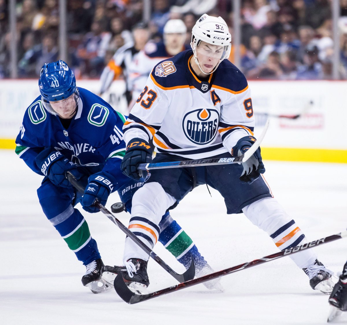 Vancouver Canucks' Elias Pettersson (40), of Sweden, takes the puck away from Edmonton Oilers' Ryan Nugent-Hopkins (93) during third period NHL hockey action in Vancouver on Sunday, Dec. 16, 2018. THE CANADIAN PRESS/Darryl Dyck.