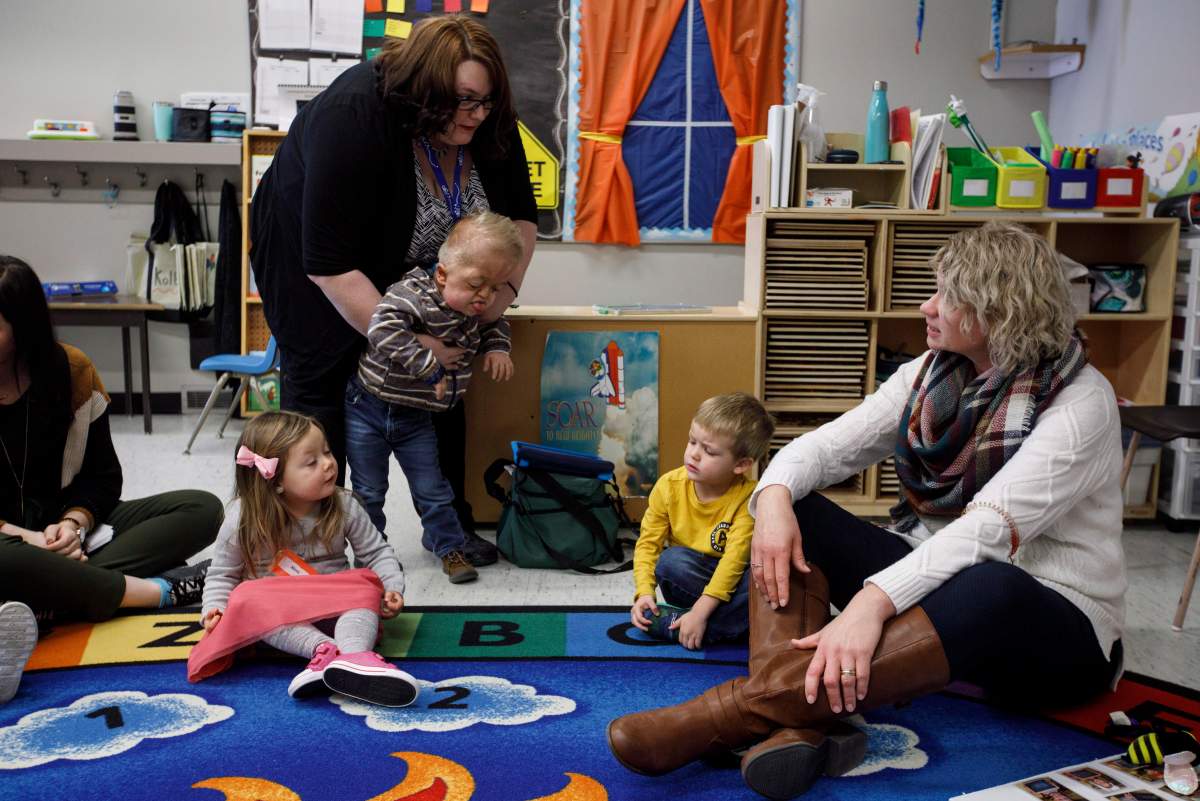 Developmental assistant Kate Jolicoeur, left, helps Porter Stanley sit as preschool instructor Vivian McDonald, right, talks with students, in Onoway, Alta., on Wednesday, November 7, 2018.