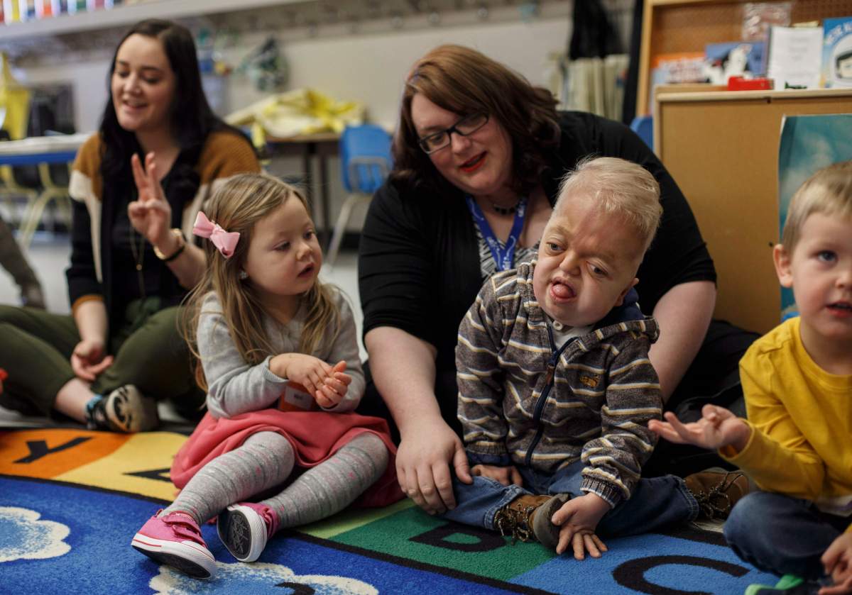 Developmental assistant Kate Jolicoeur sits with Porter Stanley, centre, during preschool in Onoway, Alta., on Wednesday, November 7, 2018.
