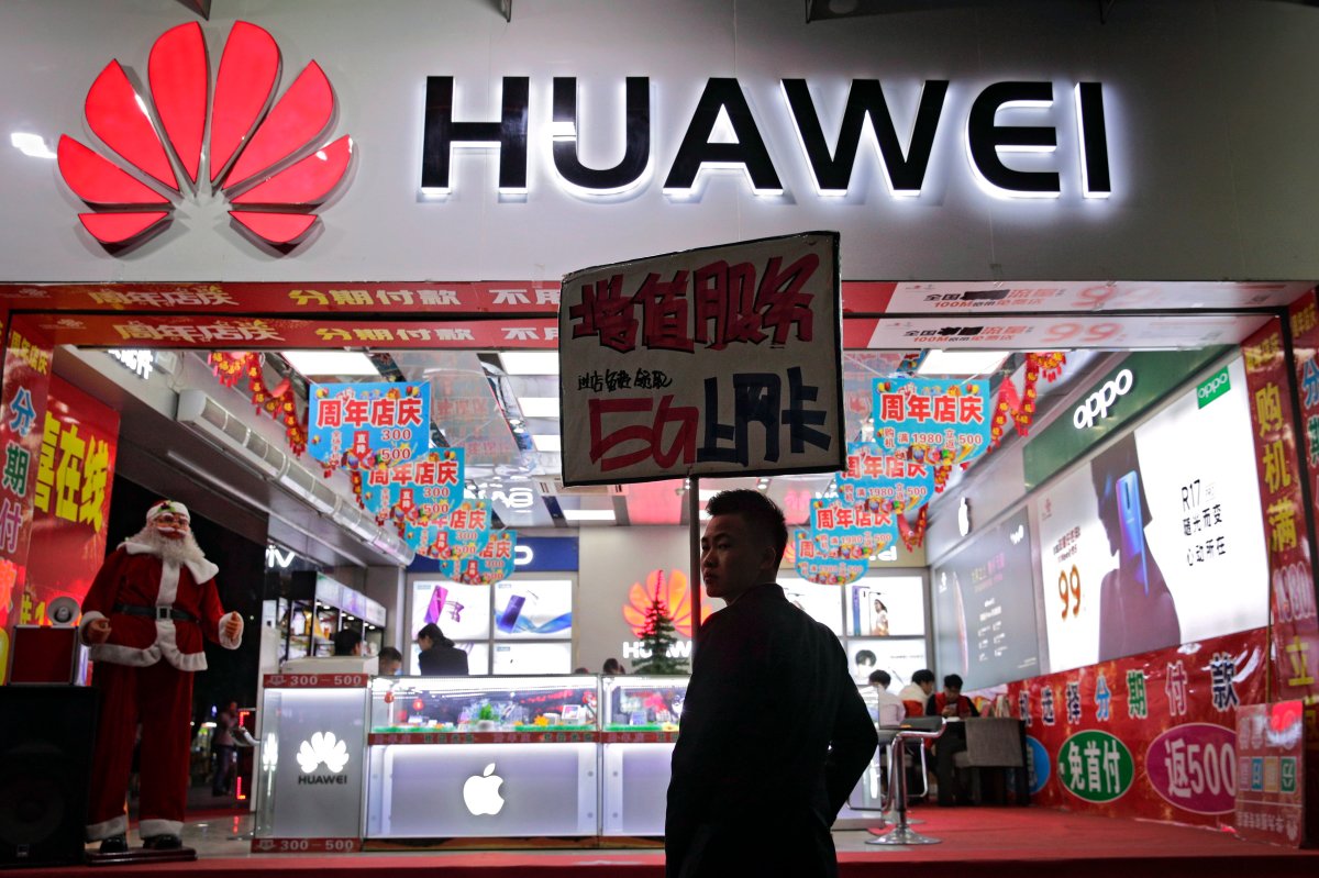 A worker holds a sign promoting a sale for Huawei 5G internet services at a mobile phones retail shop in Shenzhen in south China's Guangdong province, Tuesday, Dec. 18, 2018.
