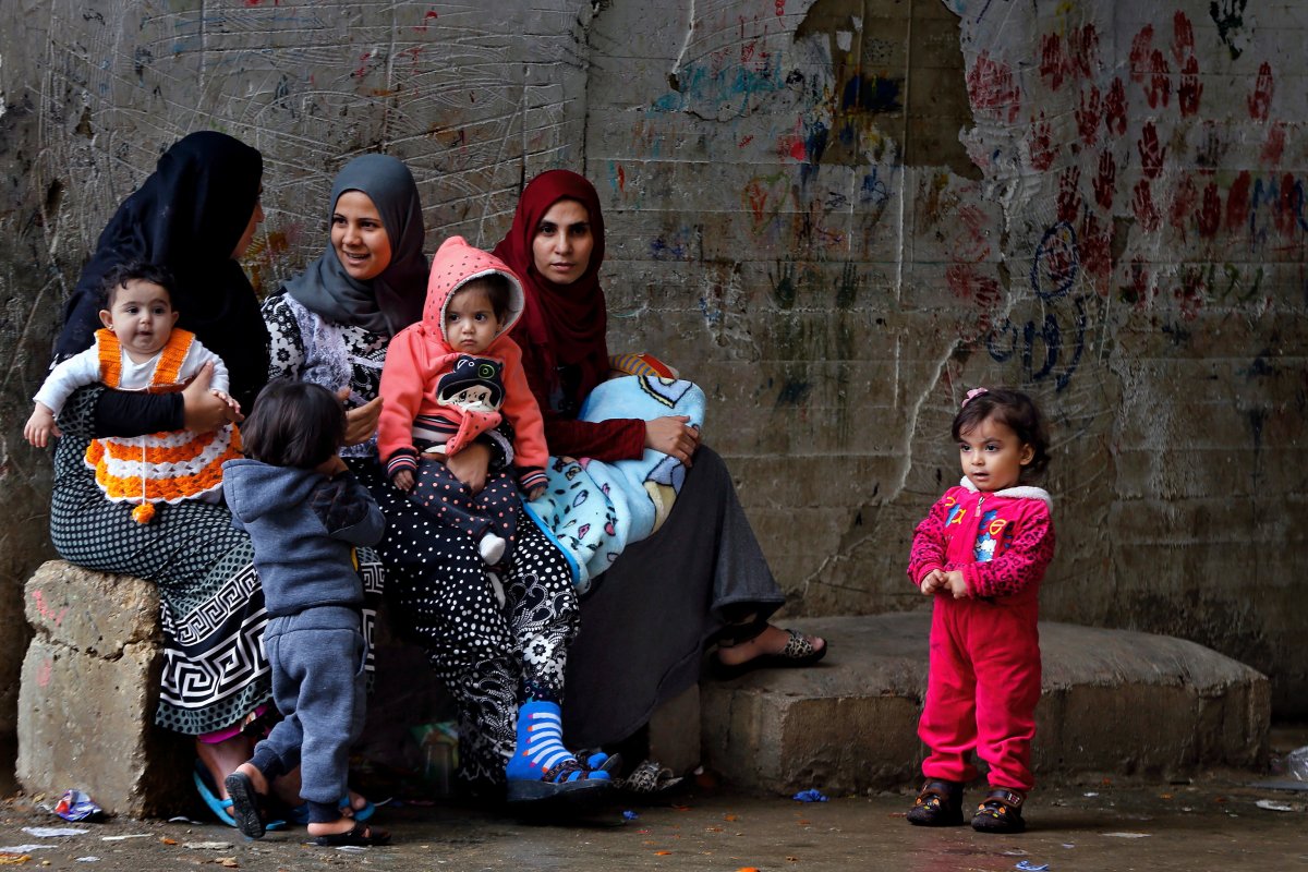 In this Tuesday, Dec. 18, 2018, photo, Syrian refugees women hold their children as they sit in Ouzai refugee compound, in the southern port city of Sidon, Lebanon. 

